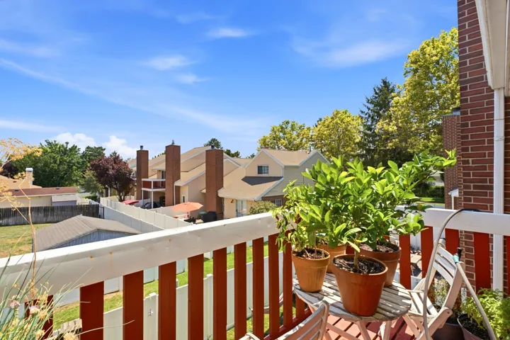 Private balcony with wood railing and brick exterior