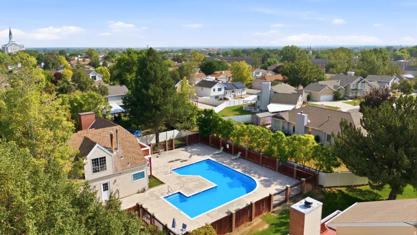 Community swimming pool with surrounding fence and paved deck