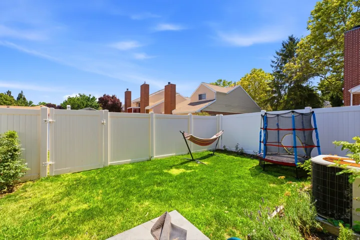 Fenced backyard featuring a manicured lawn and established landscaping