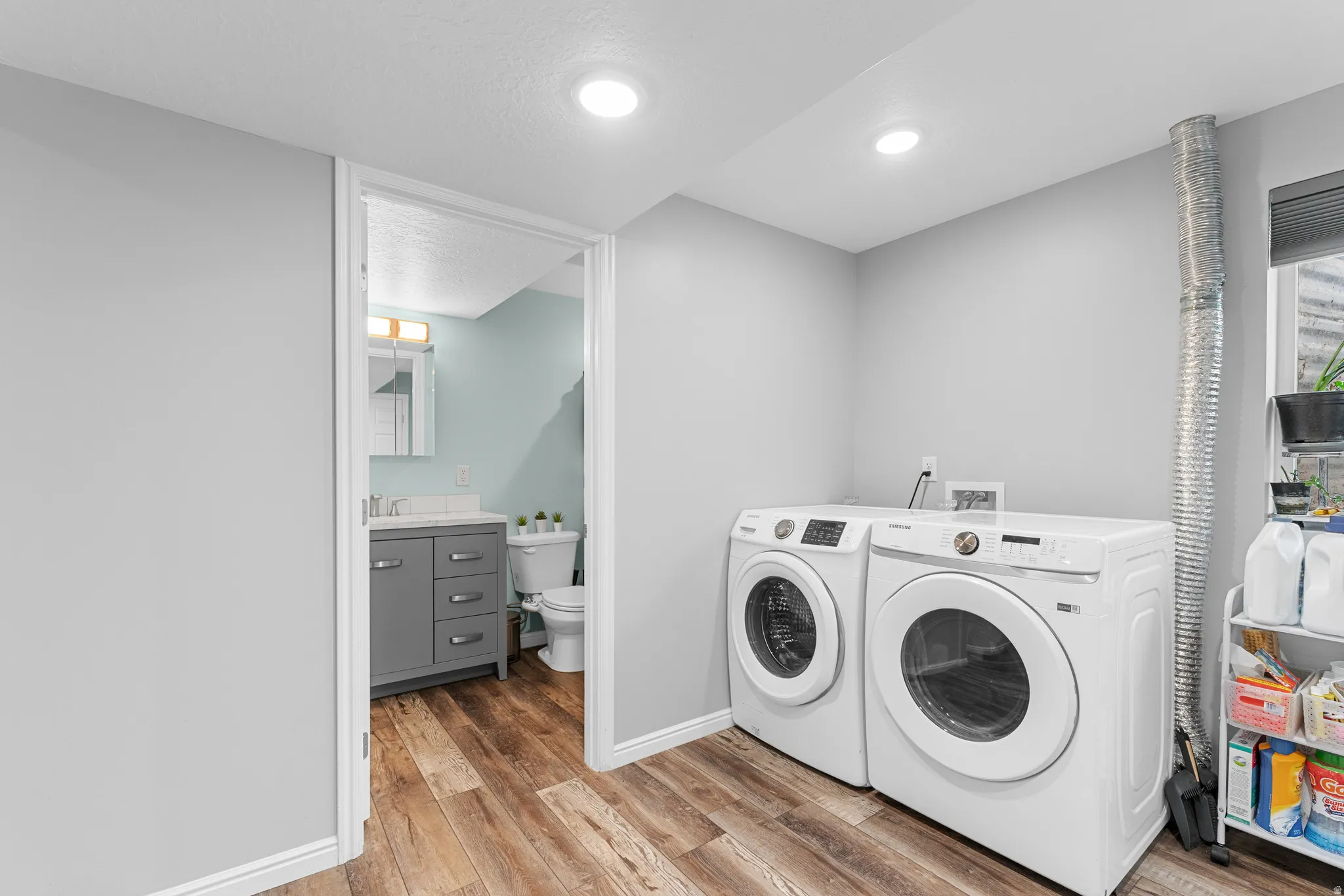 Recessed lighting, wood-finish flooring, and a window with blinds