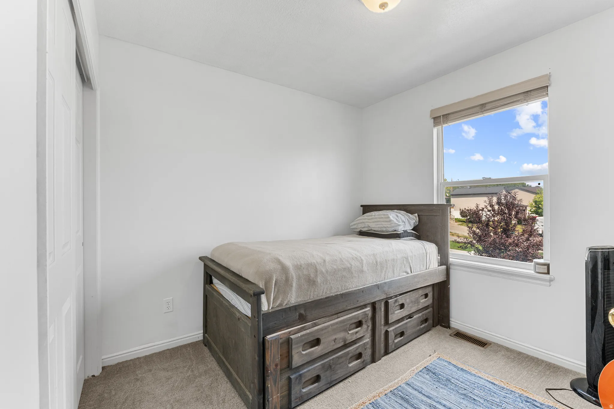 Bright room featuring a large window, neutral paint, and carpeting