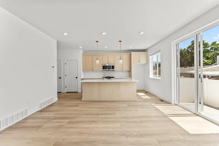 Open-concept kitchen and living area featuring wood-finish flooring
