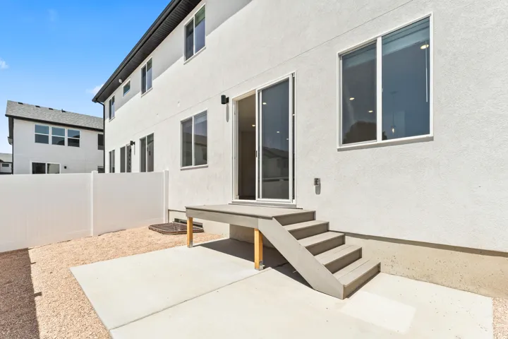 Exterior patio with direct access via sliding glass door, composite deck and steps, and privacy fence