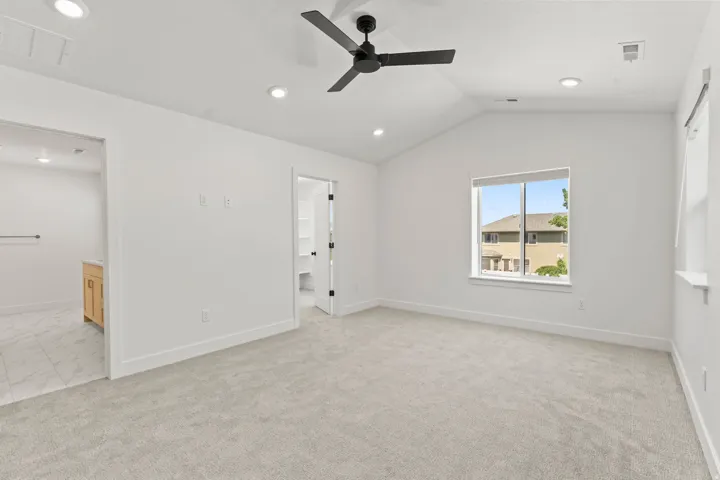 Vaulted ceiling with recessed lighting and a ceiling fan