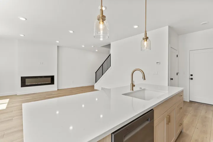 Kitchen island with a built-in sink, gold-finish faucet, and integrated dishwasher