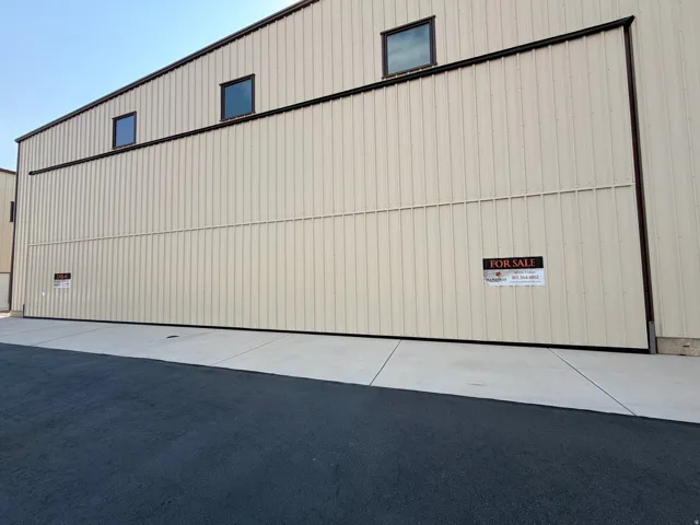 Commercial building featuring a light-colored corrugated metal exterior and a dark trim