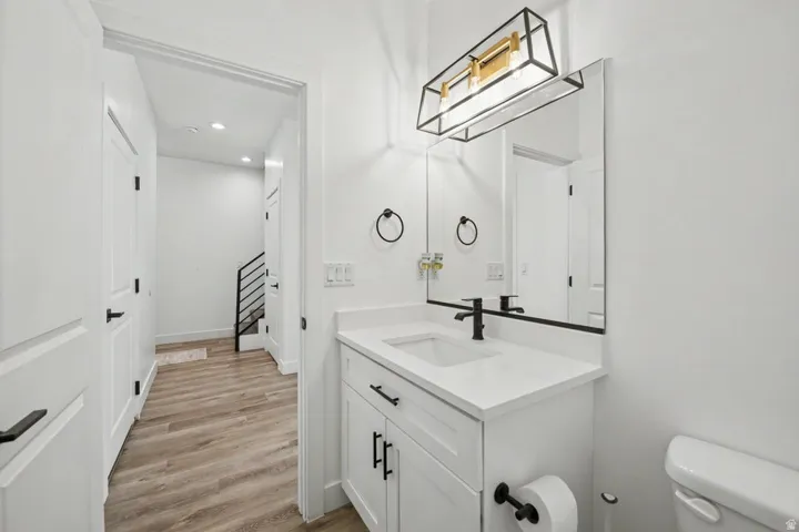 White vanity with a single basin, dark-finish faucet, and coordinating hardware