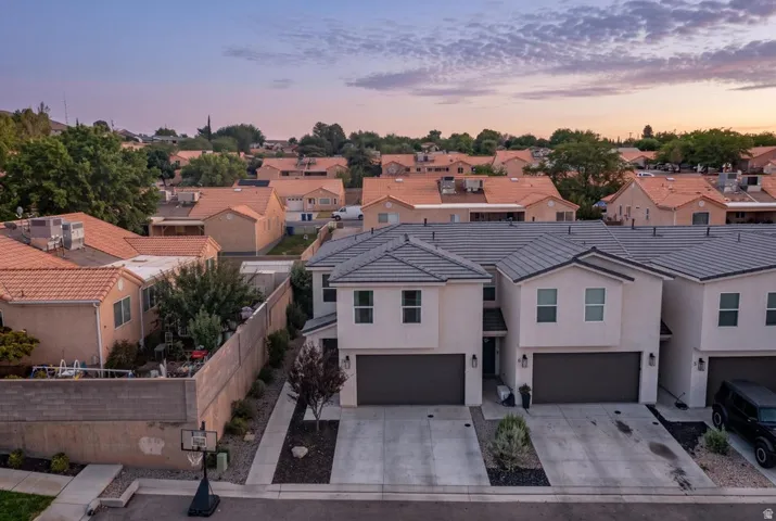 Contemporary townhome exterior with a gray tile roof, attached garage, and paved driveway