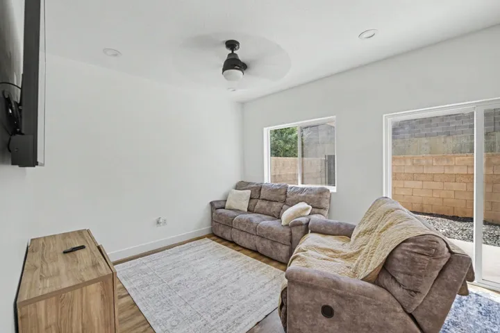 Recessed lighting, ceiling fan, wood-finish flooring, sliding glass door, and fixed pane windows