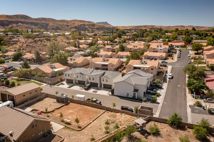 Newly constructed multi-level townhomes with two-car garages and modern light-colored exteriors