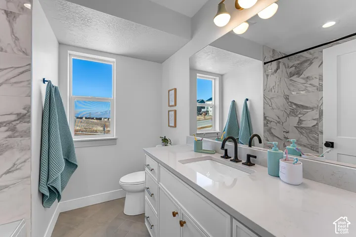 Double vanity with integrated sinks, white cabinetry, matte black fixtures, and a large wall-mounted mirror