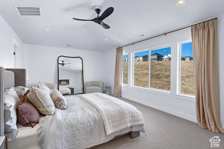 White walls featuring multiple windows with natural light, a ceiling fan, recessed lighting, and carpet flooring