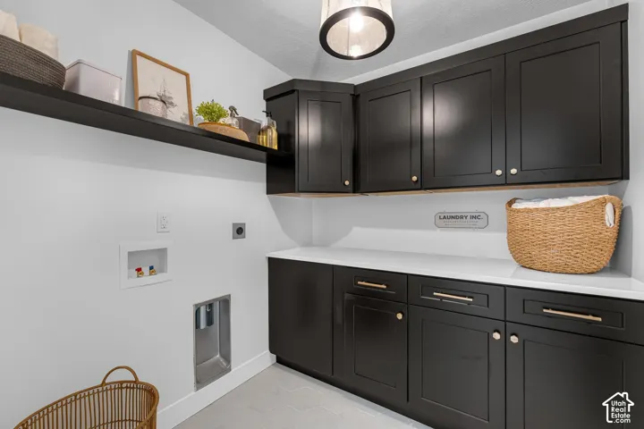 Upper and lower black cabinetry with gold-tone hardware, white countertops, and a white floating shelf