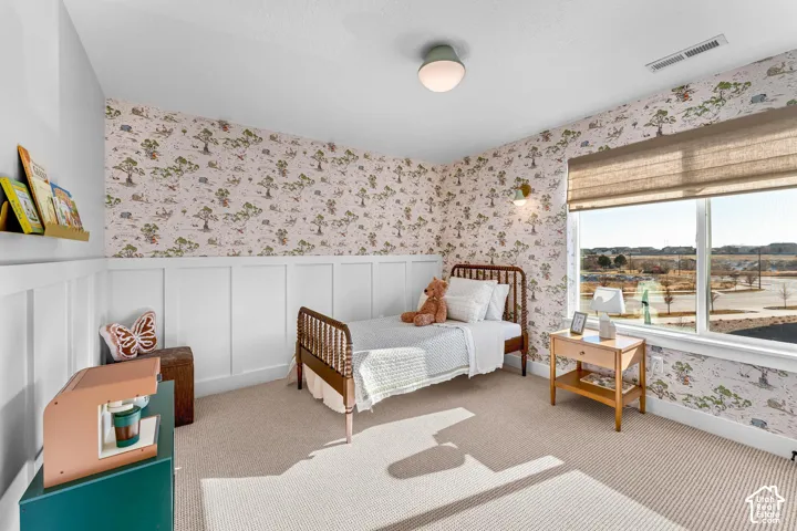 Carpeted flooring with decorative wallpaper and a board and batten wall treatment