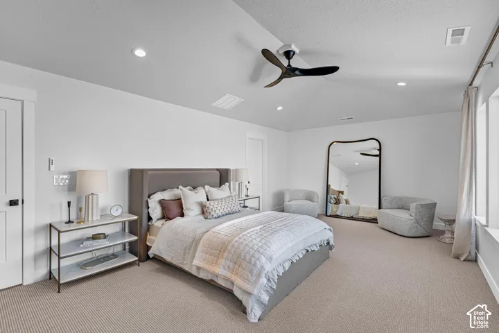 Vaulted ceiling with recessed lighting and a contemporary ceiling fan