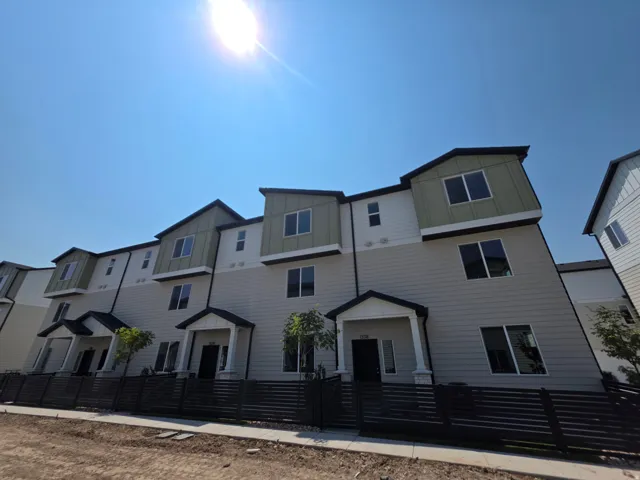 Modern multi-level exterior featuring light-toned siding, dark trim accents, and a front porch