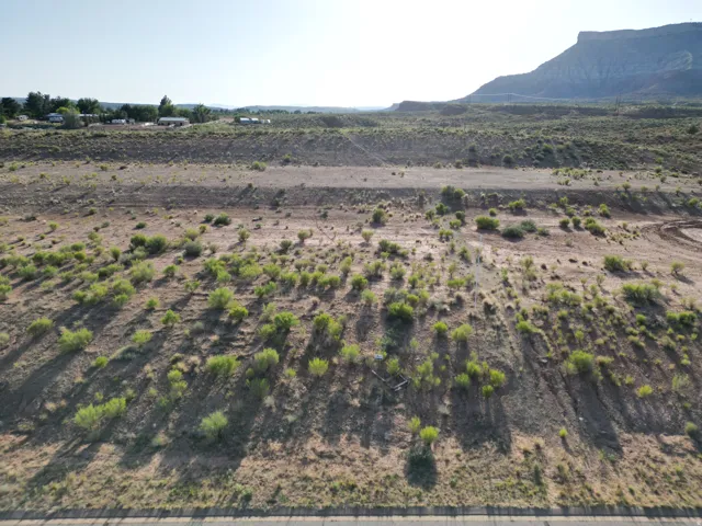 Expansive undeveloped land with sparse low-lying vegetation