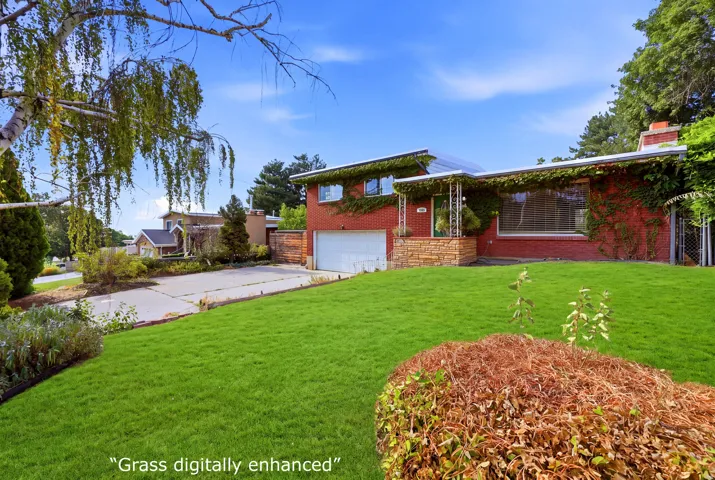 Red brick exterior with stone accents and an attached garage