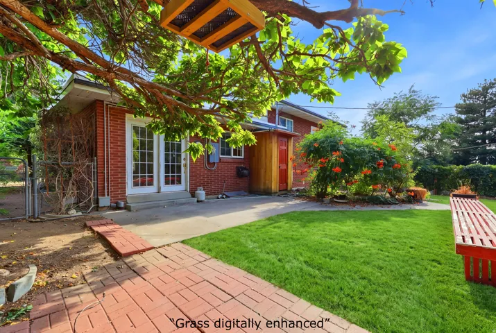 Brick exterior with double glass doors, concrete patio, and a red brick pathway