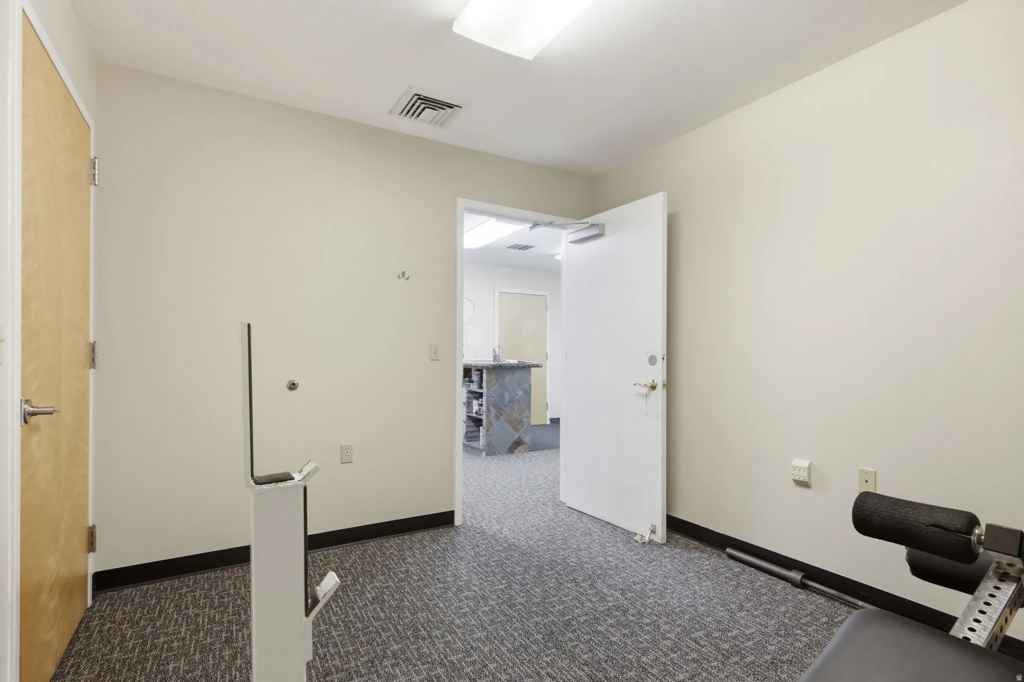 Neutral wall tones, recessed lighting, and textured carpet flooring