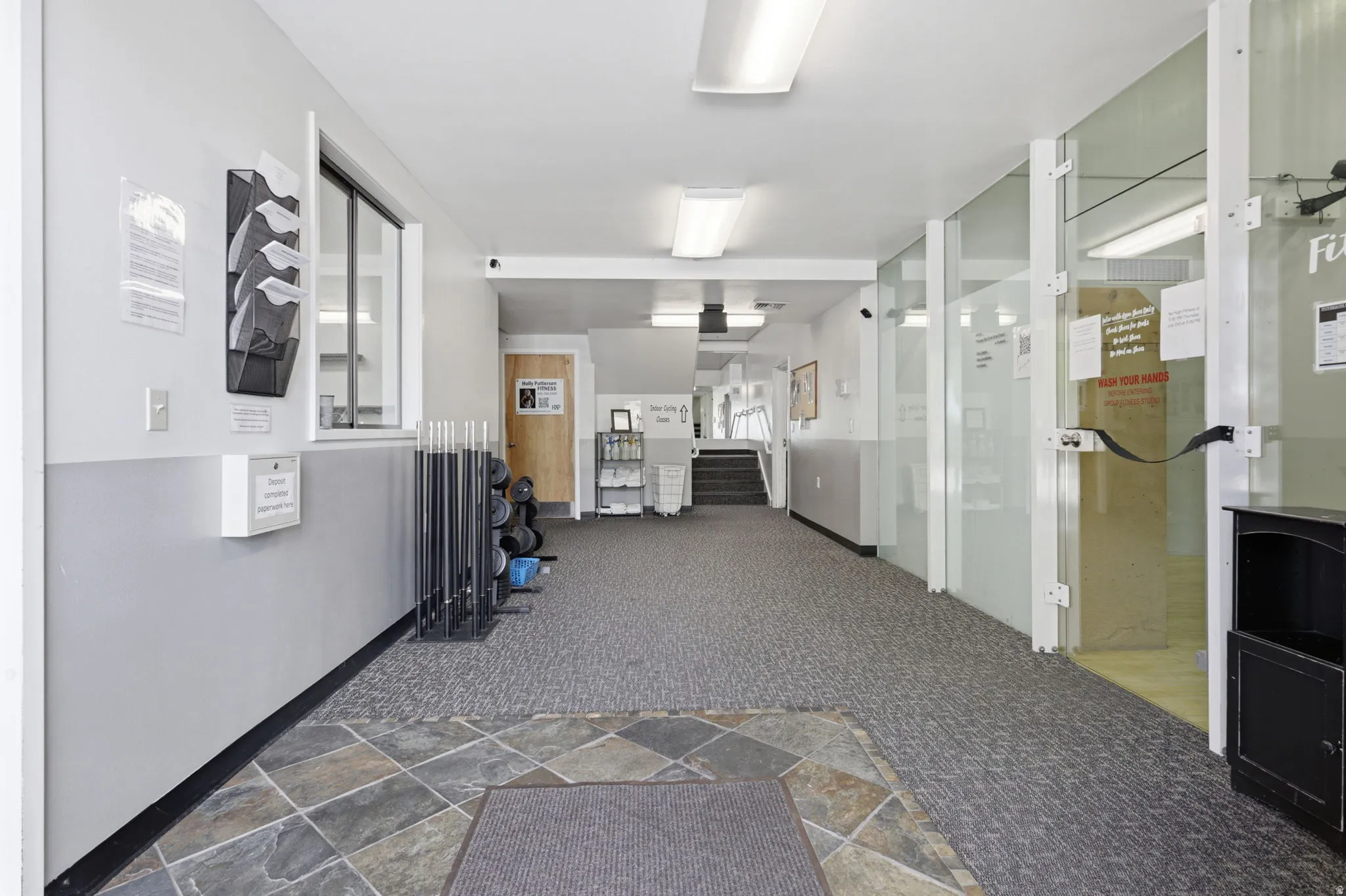 Carpeted flooring, tiled entry, and glass panel walls