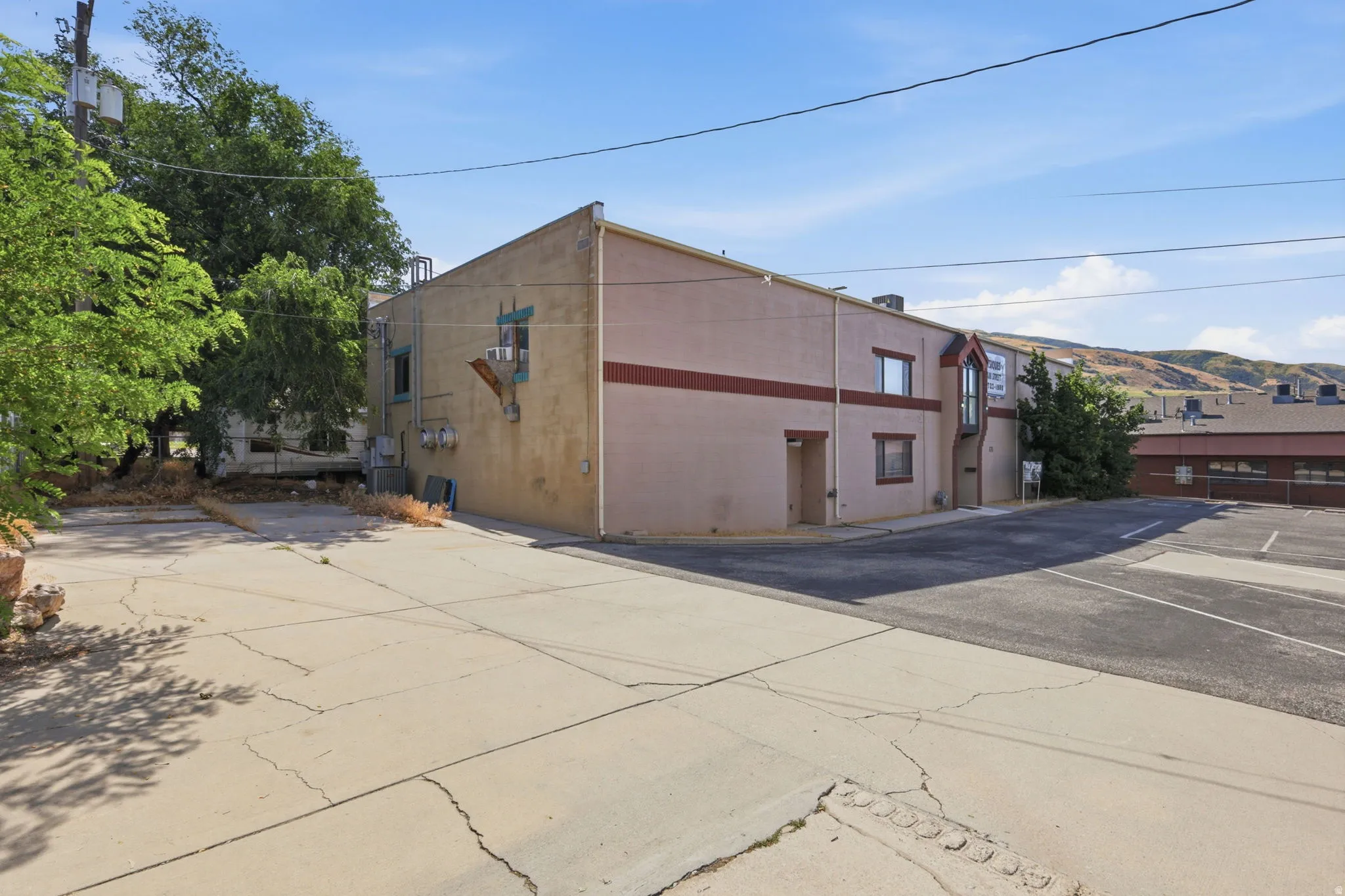Corner lot commercial or mixed-use building featuring a multi-story structure with stucco exterior, prominent roofline, and large street-facing facades