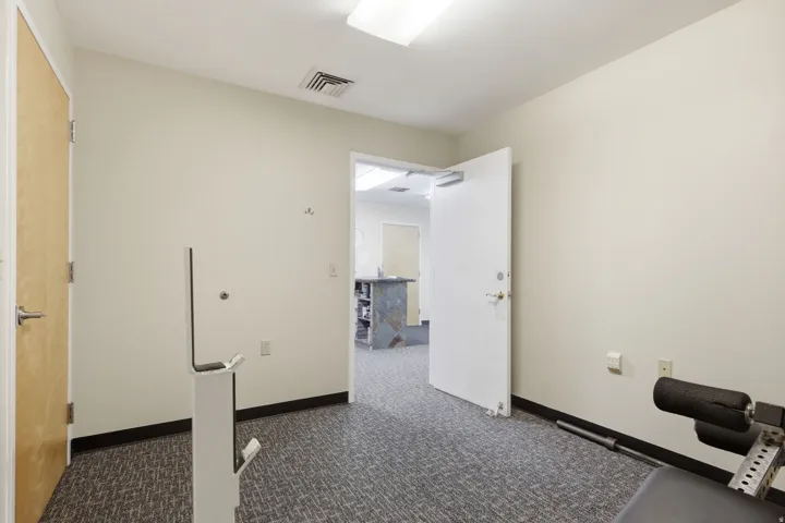 Neutral wall tones, recessed lighting, and textured carpet flooring