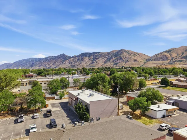 Aerial perspective showcasing a commercial property with a flat roof and modern architectural lines, surrounded by mature landscaping and established trees