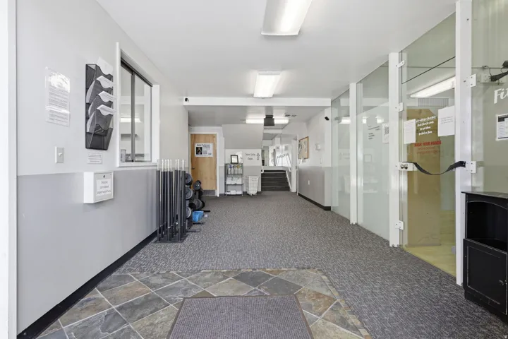 Carpeted flooring, tiled entry, and glass panel walls