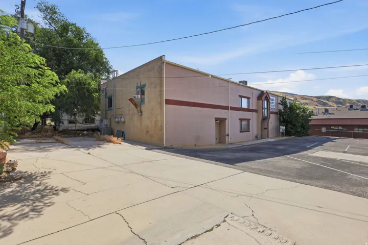 Corner lot commercial or mixed-use building featuring a multi-story structure with stucco exterior, prominent roofline, and large street-facing facades