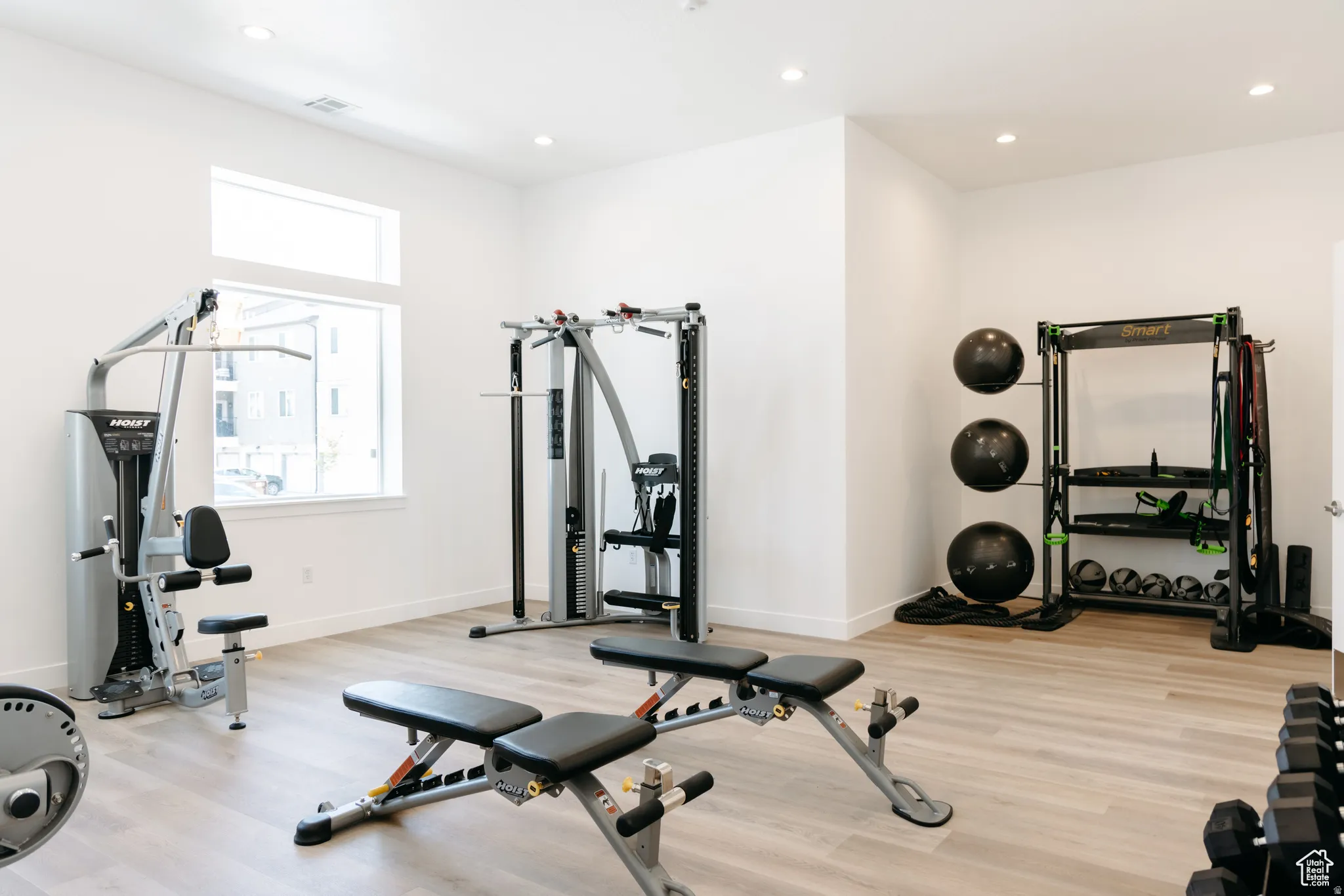 Recessed lighting, light wood-finish flooring, and white walls