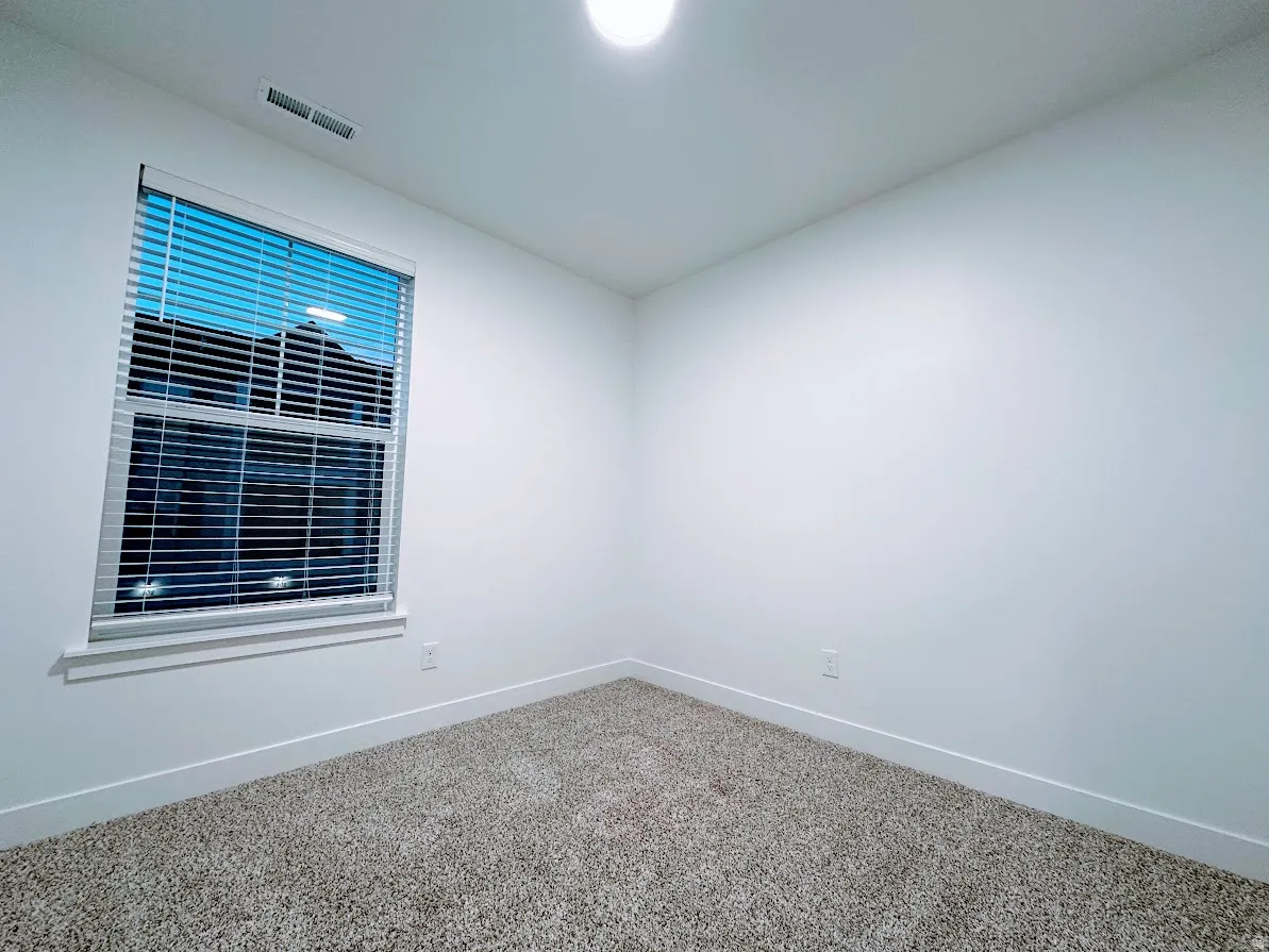Recessed lighting, neutral-toned carpeting, white walls, and a window with blinds
