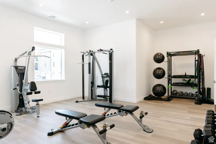 Recessed lighting, light wood-finish flooring, and white walls