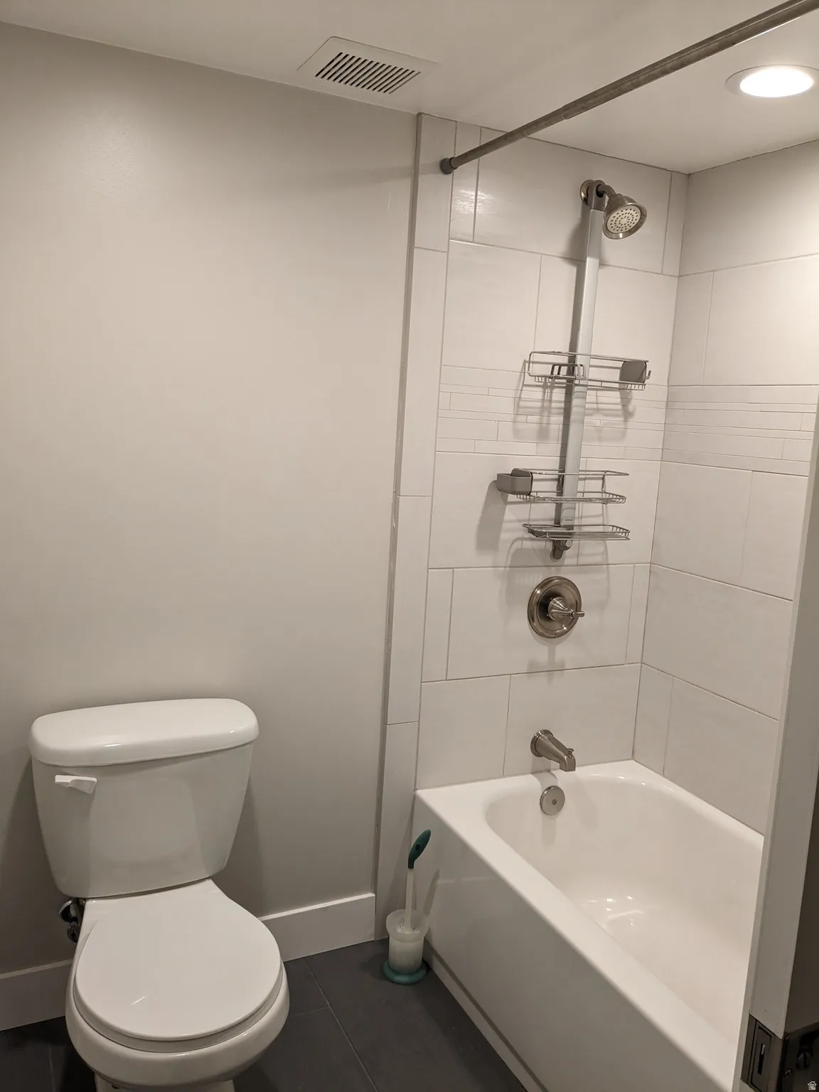 White tile tub/shower combination with brushed nickel fixtures