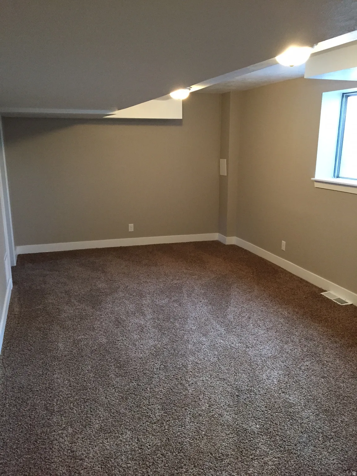 Plush carpet flooring, recessed lighting, neutral wall paint, and a built-in window