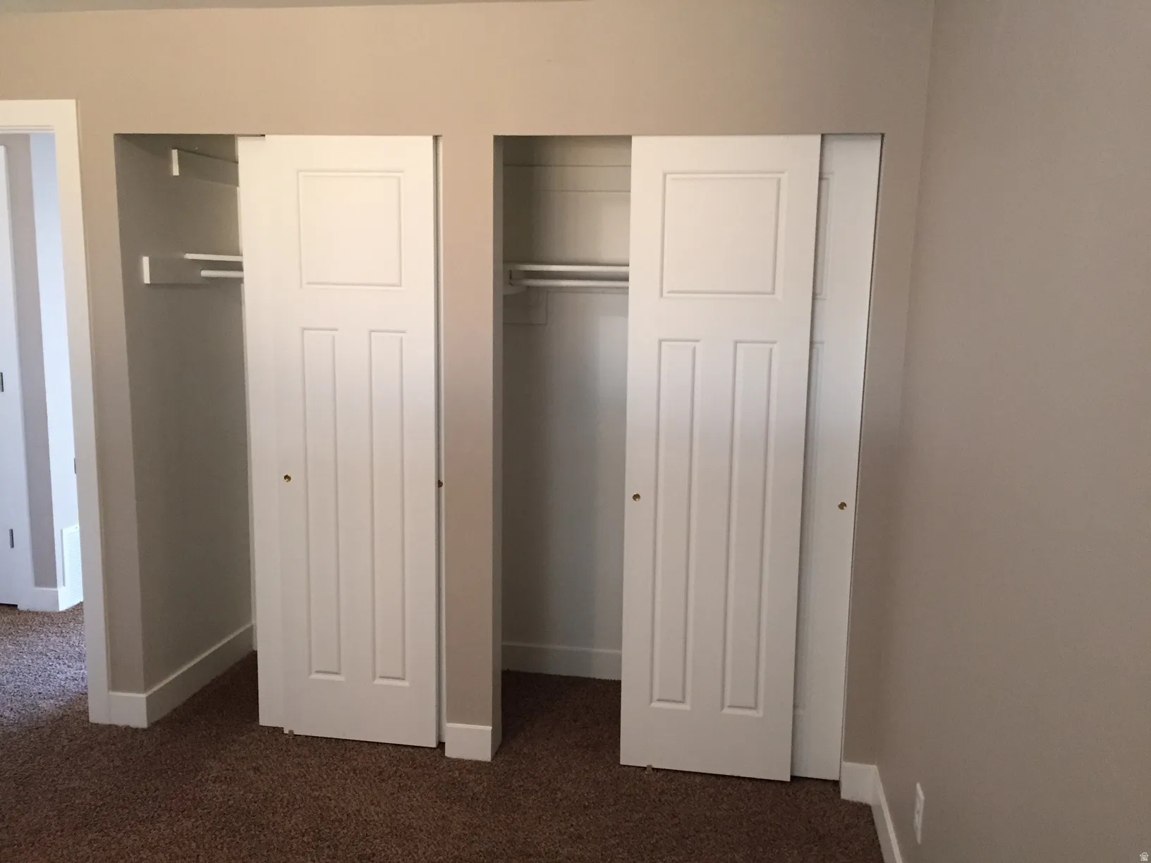 Double closet with white sliding doors and built-in shelving