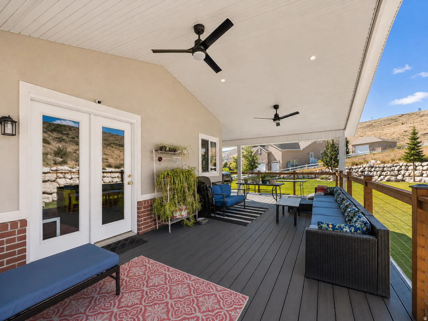 Covered patio featuring a composite deck, dual ceiling fans, recessed lighting, and white French doors