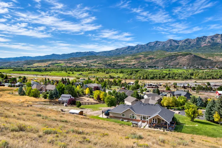 Expansive mountain backdrop, lush green valley, and established residential area