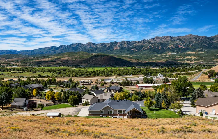 Mountain backdrop with residential properties and green landscape