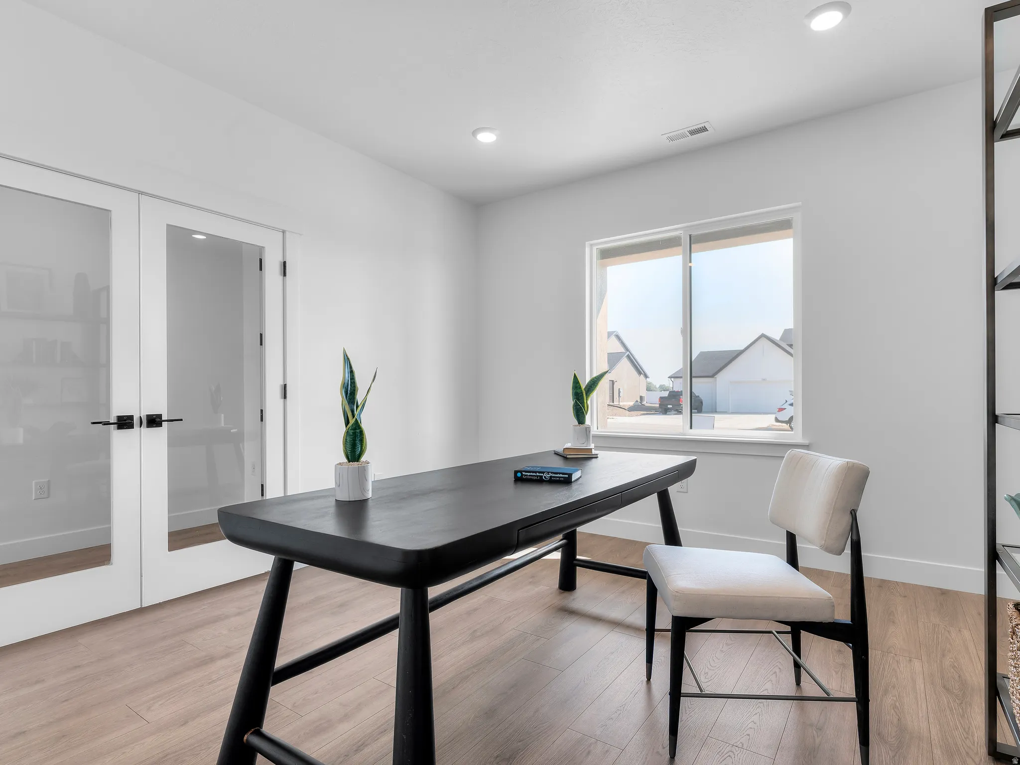Recessed lighting, wood-finish flooring, and a large window