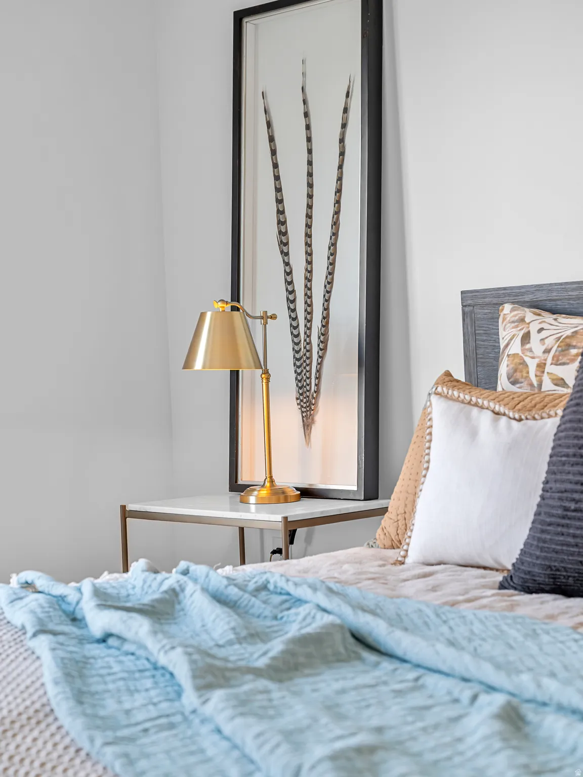 White wall finish, wood-grain headboard, and contemporary nightstand with a light-toned top
