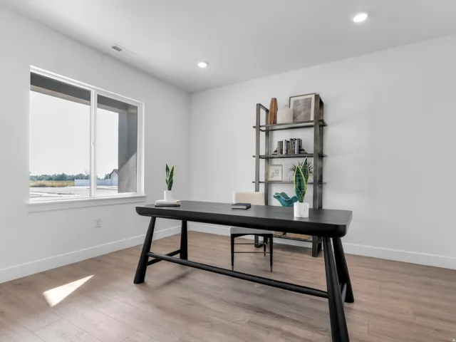 Spacious room with wood-finish flooring, recessed lighting, and a large window