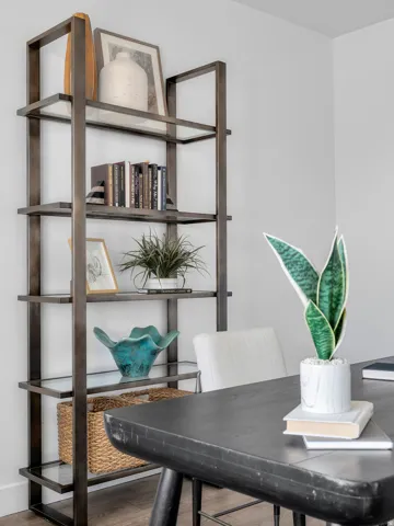 Wall-mounted shelving unit with metal frame and glass shelves
