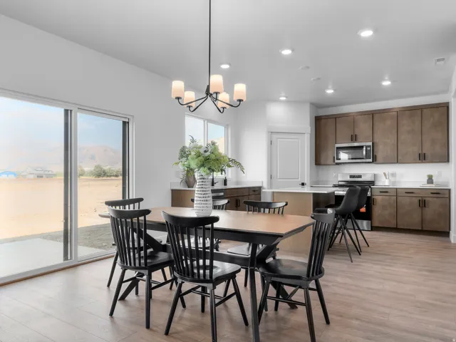 Spacious open-concept area featuring wood-finish flooring, a contemporary chandelier, and recessed lighting