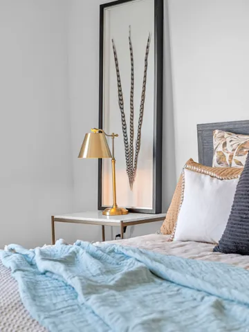 White wall finish, wood-grain headboard, and contemporary nightstand with a light-toned top