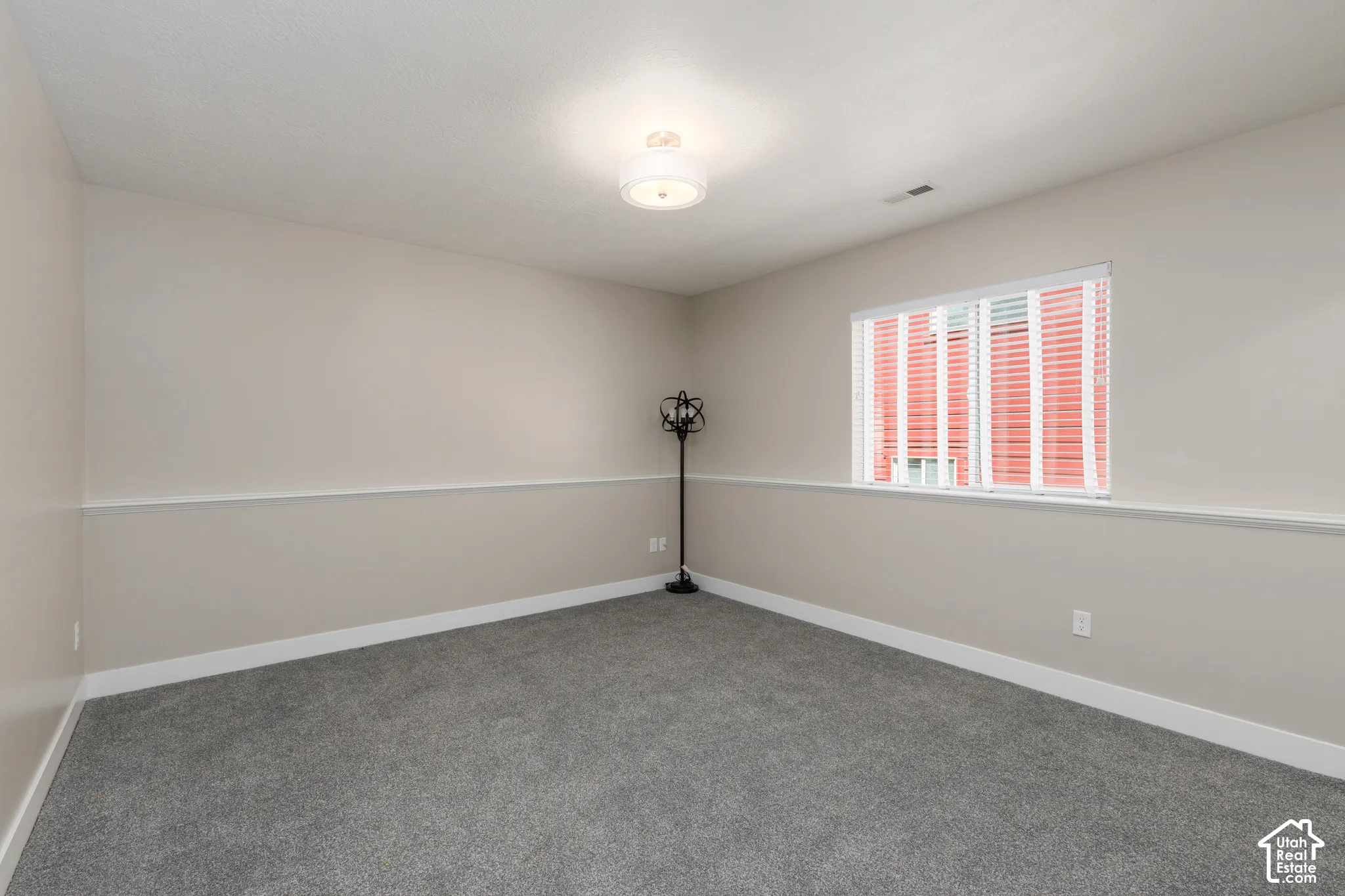 Carpeted flooring, neutral wall color, crown molding detail, white window blinds, and a flush mount ceiling light