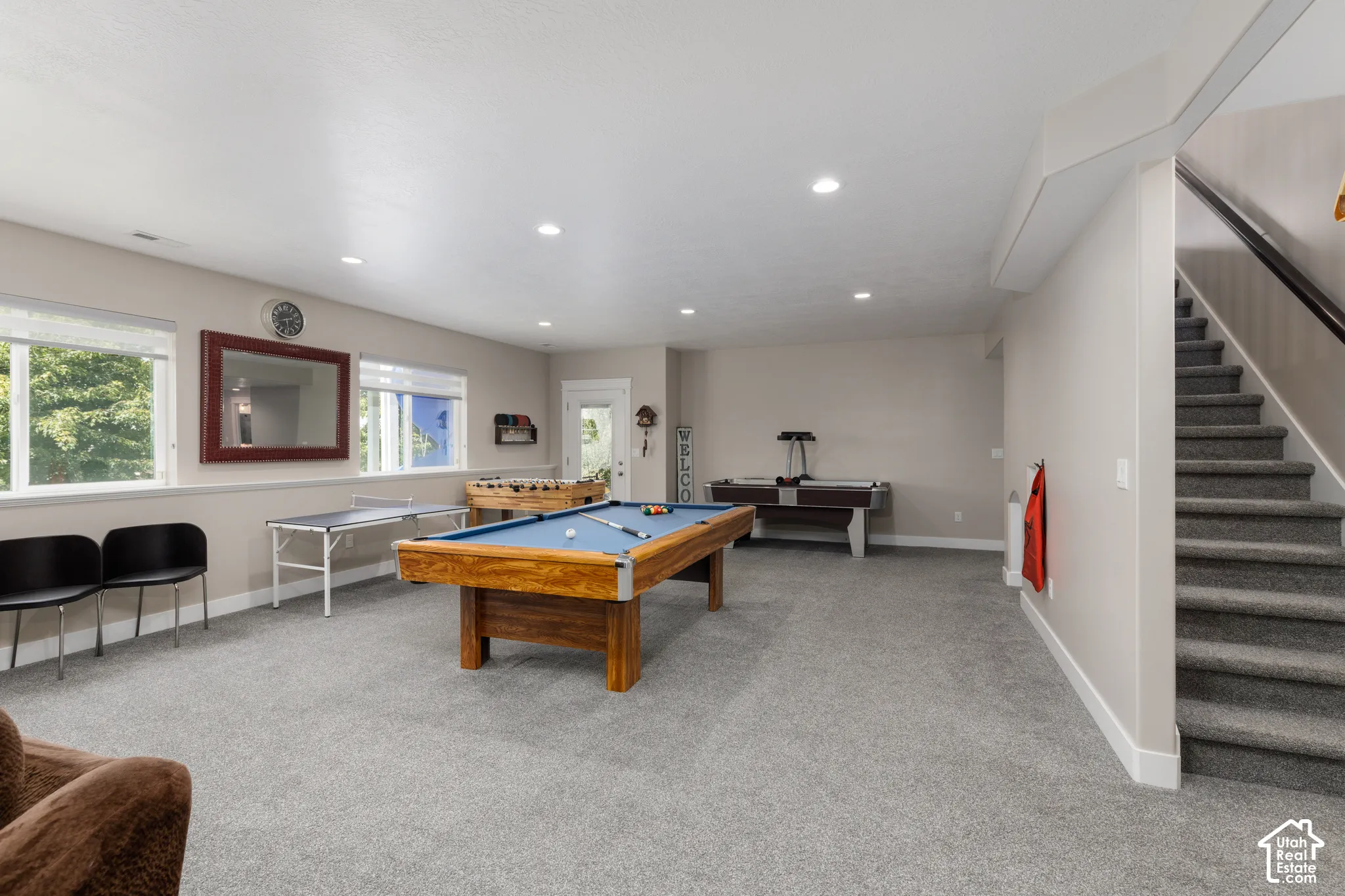 Spacious recreation room featuring recessed lighting, a carpeted floor, and multiple windows