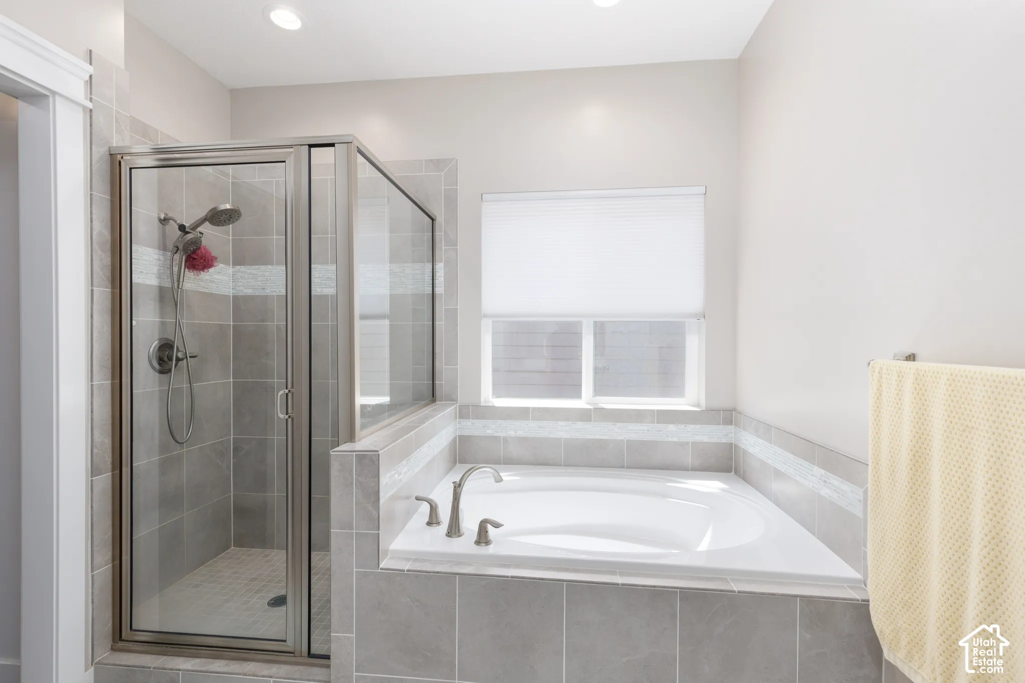Walk-in shower with clear glass enclosure and tile surround