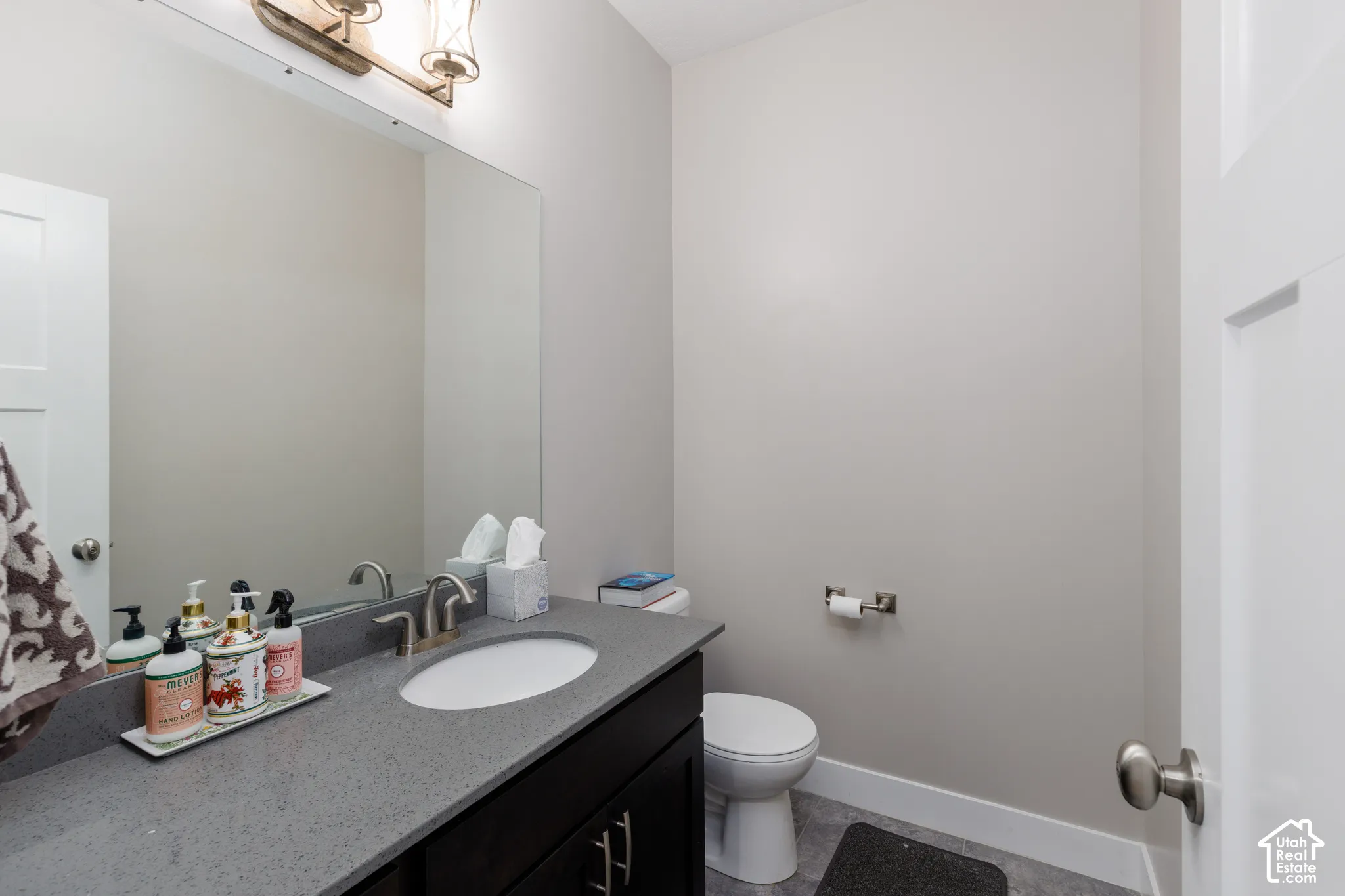 Built-in vanity with a gray countertop, undermount sink, and brushed nickel faucet