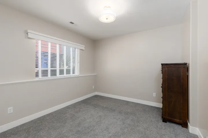 Recessed window with blinds, overhead flush-mount light fixture, and neutral wall tones